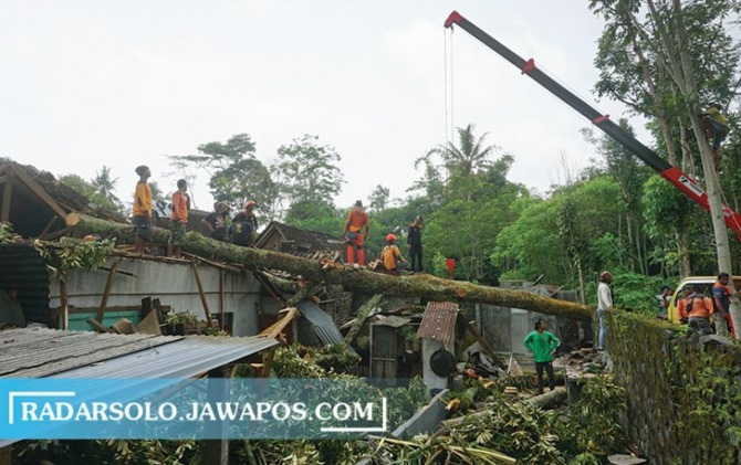 RUSAK BERAT: Relawan evakuasi pohon tumbang yang menimpa rumah di Desa/Kecamatan Kemalang. (ANGGA PURENDA/RADAR SOLO)