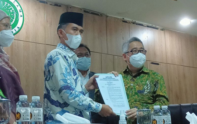 Ketua MUI Bidang Fatwa Asrorun Niam memberikan sertifikat halal vaksin Merah Putih kepada Direktur Utama PT Biotis Pharmaceuticals FX Sudirman di kantor MUI Jakarta, Kamis (10/2). (ANTARA)
