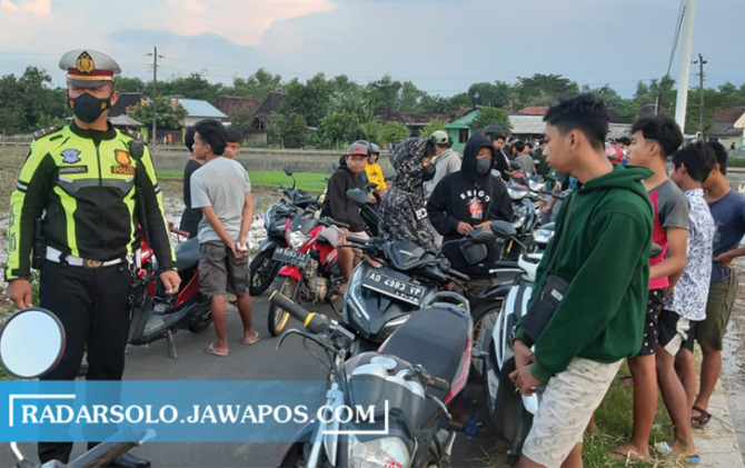 KENAKALAN REMAJA: Anggota Satlantas Polres Karanganyar amankan puluhan unit motor di sekitar Jembatan Jokowi, Kragan, Gondangrejo, Jumat (25/3). (RUDI HARTONO/RADAR SOLO)