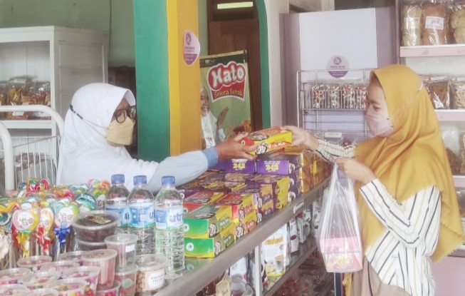 SELALU ULET: Warsini (kiri) melayani pembeli di toko oleh-oleh yang dikelolanya. Mantan ketua DPRD Karanganyar ini menikmati menjadi wirausaha. (ISTIMEWA)