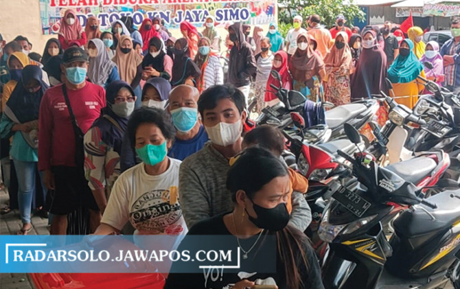 MENGULAR: Antrean panjang warga Desa Pelem, Kecamatan Simo untuk mendapatkan minyak goreng, Senin (7/3). (RAGIL LISTIYO/RADAR SOLO)