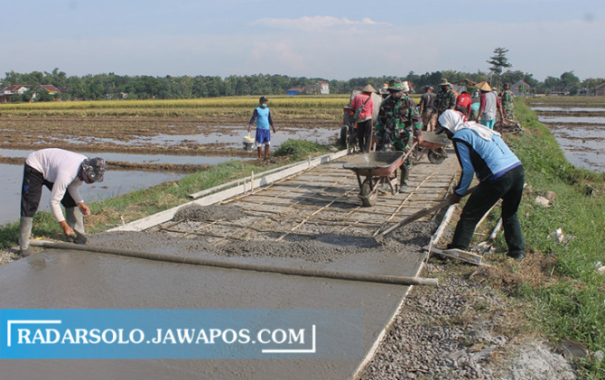 INOVASI: Pengecoran jalan di Geneng, Desa Wonotolo, Kecamatan Gondang dalam program karya bakti Kodim 0725/Sragen. (AHMAD KHAIRUDIN/RADAR SOLO)