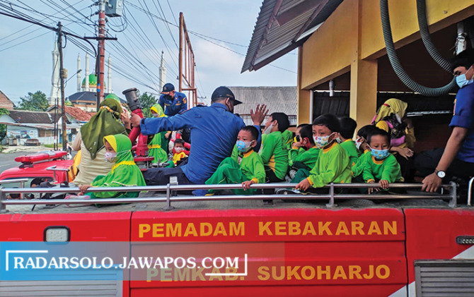 GEMBIRA: Murid TK naik armada damkar Satpol PP Sukoharjo dalam kegiatan outing class, Jumat (25/3). (IWAN KAWUL/RADAR SOLO)