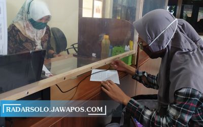 PAKAI PELINDUNG: Pemohon urus kartu kuning di Dinas Tenaga Kerja dan Transmigrasi Wonogiri, Jumat (26/6).