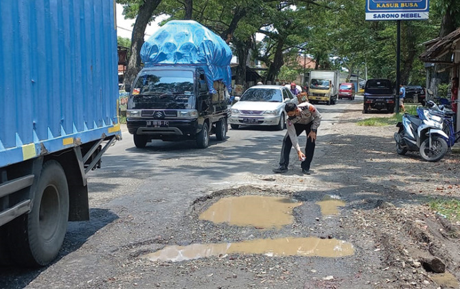 AGAR WASPADA: Anggota Satlantas Polres Sukoharjo beri tanda lubang jalan, kemarin. (ISTIMEWA)