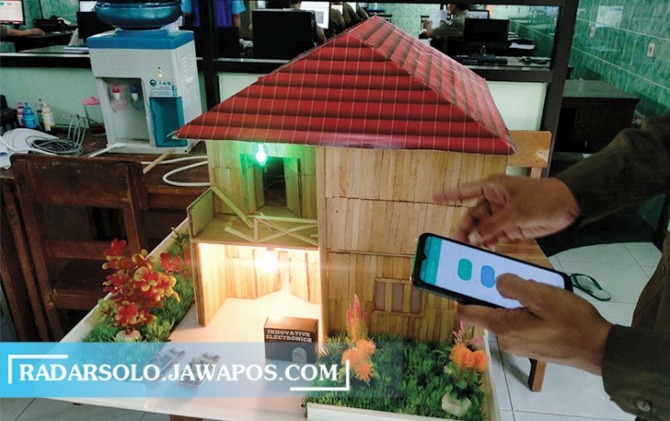 CANGGIH: Cara kerja smart home system menggunakan smartphone dan maket hunian di salah satu SMK swasta di Kota Solo, kemarin (25/3). (SEPTIAN REFVINDA/RADAR SOLO)