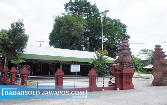 BERSOLEK: Pekerja mengecat pagar Masjid Darul Mutaqin. (RENDY/RADAR SOLO)
