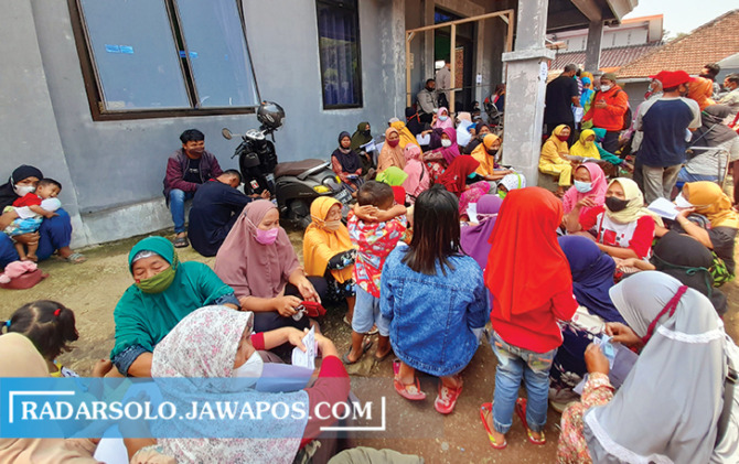 LESEHAN: Puluhan warga Delingan antre mendapatkan BLT migor dan BPNT di Kantor Kelurahan Delingan, Karanganyar, Jumat (15/4) siang. (RUDI HARTONO/RADAR SOLO)