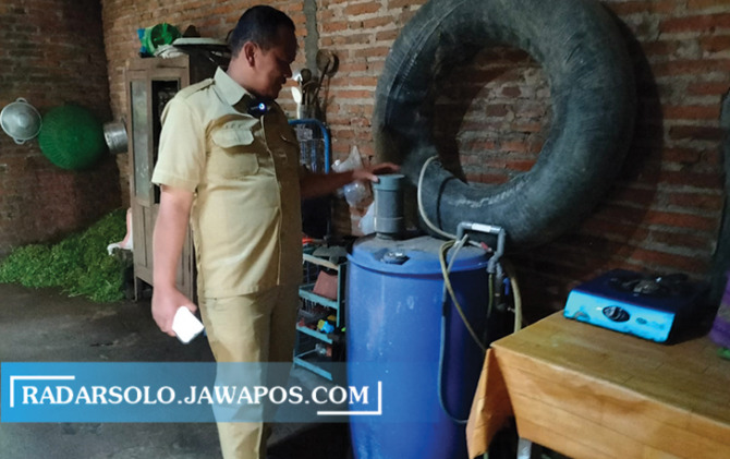 HASIL KERJA WARGA: Kades Urutsewu memperlihatkan biogas portabel (drum biru) di salah satu rumah warga. (RAGIL LISTYO/RADAR SOLO)