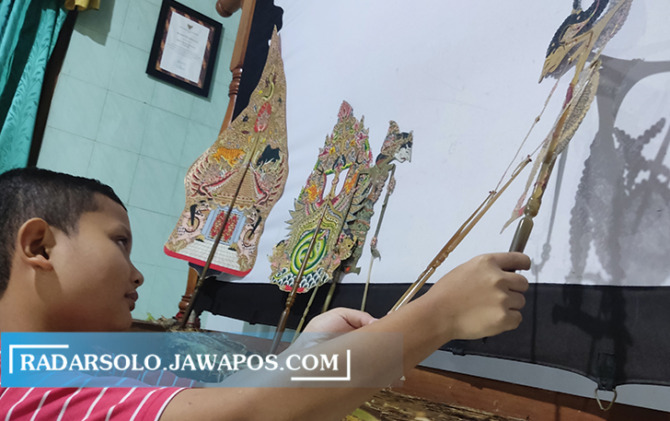 Dalang cilik Nareswara Praba berlatih di rumahnya. (IWAN ADI LUHUNG/RADAR SOLO)