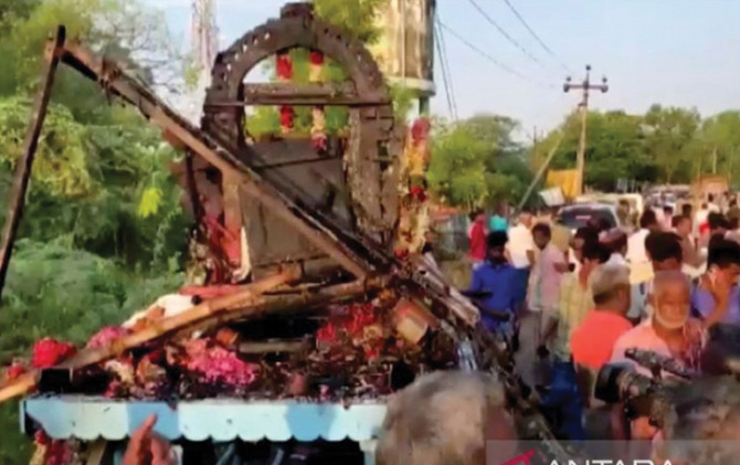 Orang-orang berkumpul di sekitar kereta yang rusak setelah kabel listrik tegangan tinggi jatuh di atasnya, menewaskan sedikitnya 11 orang saat prosesi di sebuah festival kuil di Desa Kalimedu, Distrik Thanjavur, India, Rabu (27/4). (ANTARA)