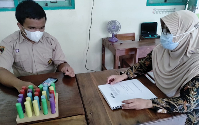 Seorang guru mengajar anak berkebutuhan khusus di sekolah inklusi.