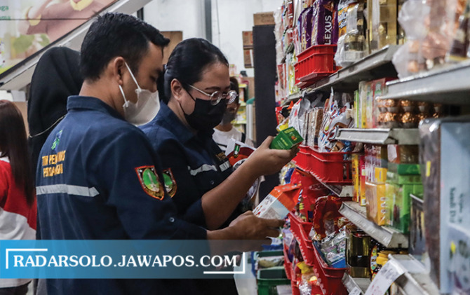 CEK KEDALUWARSA: Petugas gabungan mengecek makanan kemasan di kios pasar dan toko modern di Kota Solo, Kamis (14/4). (M. IHSAN/RADAR SOLO)