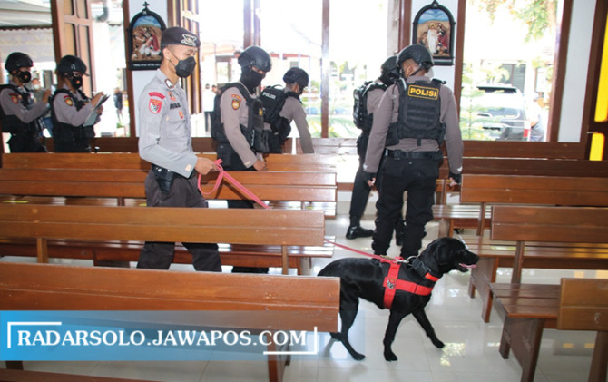 TERJUNKAN ANJING PELACAK: Personel Polres Karanganyar mengecek keamanan salah satu gereja di Kota Karanganyar, Kamis (14/4). (RUDI HARTONO/RADAR SOLO)