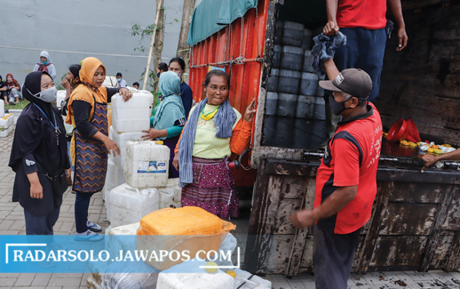 MENGULAR: Antrean pedagang yang hendak membeli minyak goreng curah, dalam operasi pasar yang digelar Dinas Perdagangan Kota Surakarta, pekan lalu. (M. IHSAN/RADAR SOLO)
