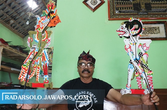 TETAP BERTAHAN: Giyarto menunjukkan wayang kardus hasil produksinya, Sabtu (16/4). (IWAN ADI LUHUNG/RADAR SOLO)