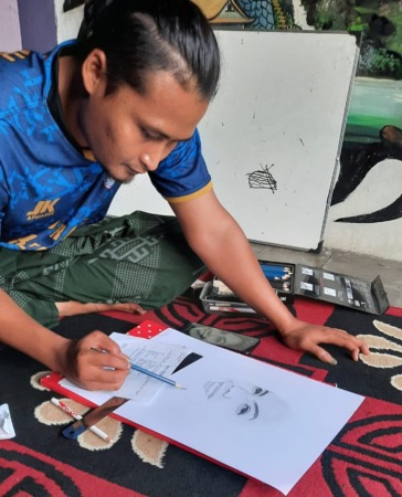 FOKUS: Muhammad Mudrikul Ma’arif tengah menyelesaikan karya sketsa wajah yang tengah dipesan. (AHMAD KHAIRUDIN/RADAR SOLO)