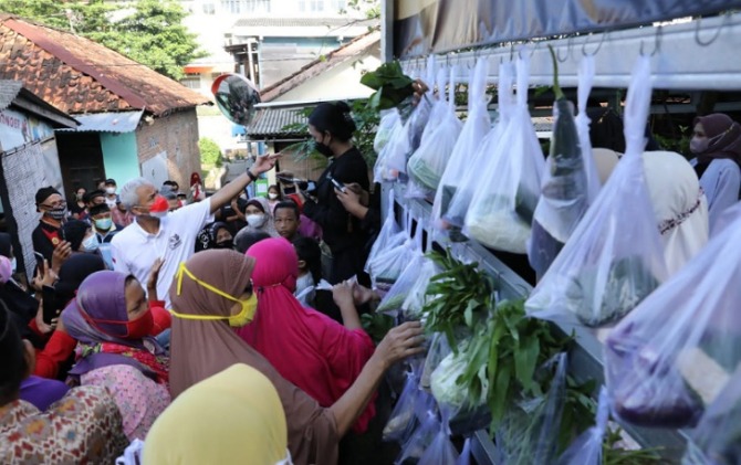 Gubernur Jateng Ganjar Pranowo bersama emak-emak di pasar murah Kagama Canthelan yang dilakukan digelar Keluarga Alumni Gadjah Mada (Kagama) di Jogja.