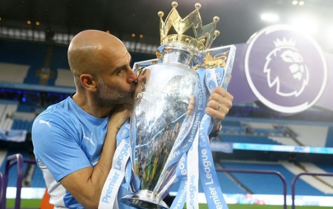 Manajer Manchester City Pep Guardiola mencium trofi Liga Premier setelah mengalahkan Aston Villa dalam pertandingan terakhir musim 2021/2022. Pertandingan sekaligus menjadi penentu status juara liga di Etihad Stadium, Manchester, Inggris, Minggu (22/5). (