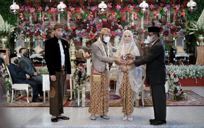 Ketua MK Anwar Usman menunjukkan buku nikah usai resmi menjadi suami adik Jokowi, Idayati, Kamis (26/5). (ISTIMEWA)