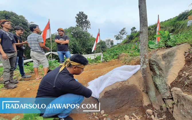 BUKTI SEJARAH: Kusworo Rahardian menunjukkan Prasasti Wonosegoro bertuliskan huruf Jawa kuno di Cepogo, Boyolali. (RAGIL LISTIYO/RADAR SOLO)