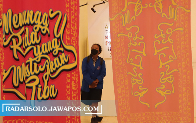 MENGAMATI: Seorang siswa sedang melihat karya seni yang dipajang dalam Typefest 2022, Typefest 2022, International Typography Biennial di TBJT, kemarin (11/5). (M. IHSAN/RADAR SOLO)