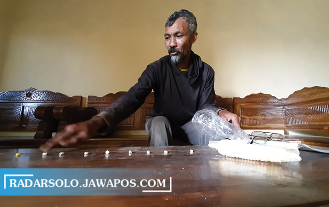 LESTARIKAN TRADISI: Paiman mempraktikkan cara menghitung hari baik berdasar primbon Jawa. (RAGIL LISTIYO/RADAR SOLO)