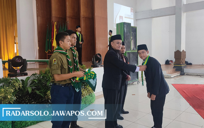 SIMBOLIS: Direktur Ponpes Dimsa Kyai Ali Rosyidi (tengah) sematkan kalung wisuda saat Akhirussanah, Sabtu (28/5). (AHMAD KHAIRUDIN/RADAR SOLO)