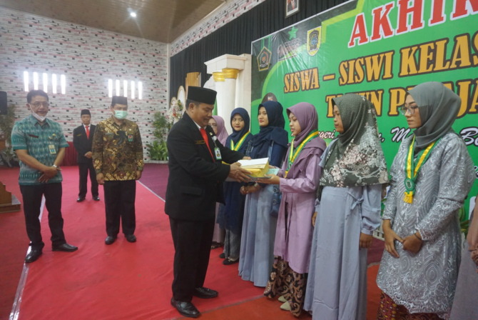 TERBAIK: Kepala MTsN 7 Klaten Sukidi serahkan penghargaan kepada siswa berprestasi. (ANGGA PURENDA/RADAR SOLO)