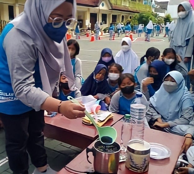 BAHAN ALAMI: Guru salah satu SD negeri di Kota Solo mengajarkan cara pengolahan dan penyajian sirup dari ekstrak bunga telang. Foto bawah, sirup bunga telang dicampur lidah buaya. (ISTIMEWA)