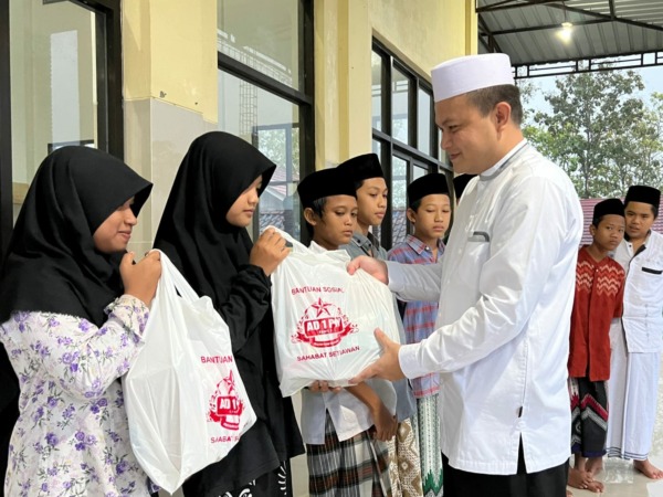 BERBAGI: Setiawan AD 1 PM bagikan bingkisan kepada Anak Yatim Piatu dan Dhuafa di  teras Masjid Jami Umar Bin Khotob, Jumat (17/6). (ISTIMEWA)