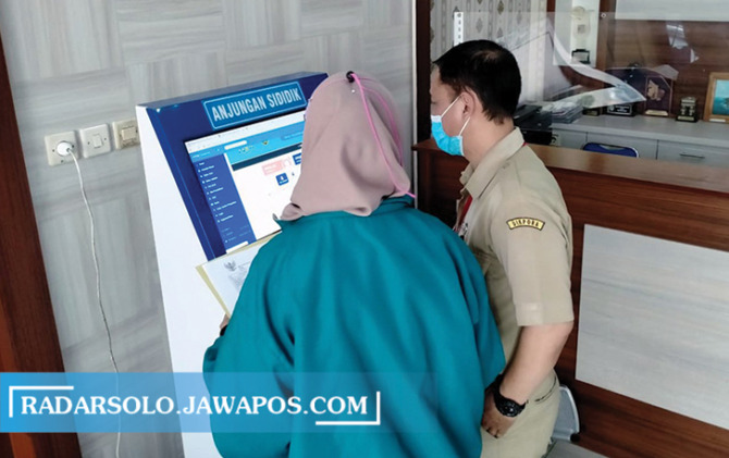 DIPANDU: Warga yang panik PPDB online jalur afirmasi mendapatkan pelayanan di anjungan sididik di Disdik Kota Surakarta, kemarin. (SEPTIAN REFVINDA/RADAR SOLO)
