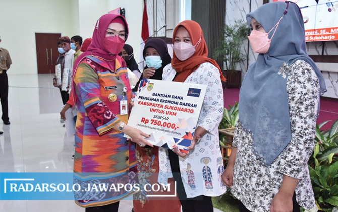 SIMBOLIS: Bupati Sukoharjo Etik Suryani serahkan bantuan kepada pelaku UMKM dan elemen masyarakat di Menara Wijaya Lantai 10, Selasa (14/6). (IWAN KAWUL/RADAR SOLO)