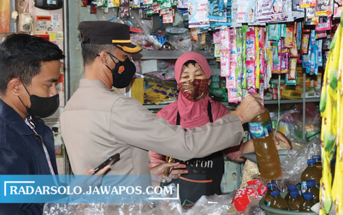 SIDAK RUTIN: Anggota Polres Karanganyar mengecek penjualan migor curah di pasar tradisional. (RUDI HARTONO/RADAR SOLO)