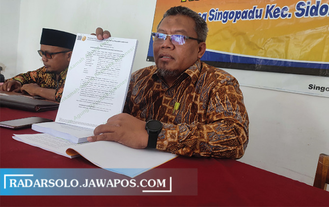 TUNJUKKAN BUKTI: Kuasa hukum salah satu bakal calon PAW Kades Singopadu, Sri Kalono tunjukkan bukti bahwa dua bakal calon pernah jalani pidana. (AHMAD KHAIRUDIN/RADAR SOLO)