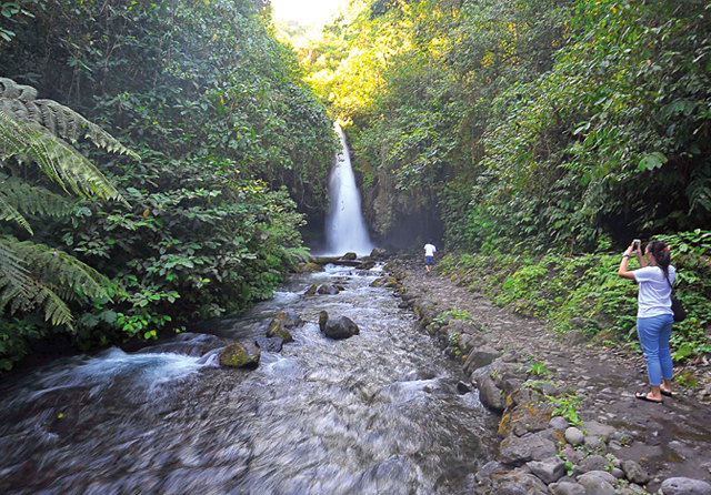 INDAH: Seorang pengunjung mengambil gambar pemandangan di sekitar Air Terjun Telunjuk Raung. Air terjun itu terlihat berbentuk jari telunjuk. (Ramada Kusuma/Jawa Pos Radar Banyuwangi)