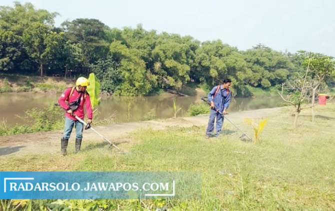 TANPA PAMRIH: Anggota tim gorong-gorong Solo beraksi membersihkan bantaran Sungai Bengawan Solo. (SILVESTER KURNIAWAN/RADAR SOLO)