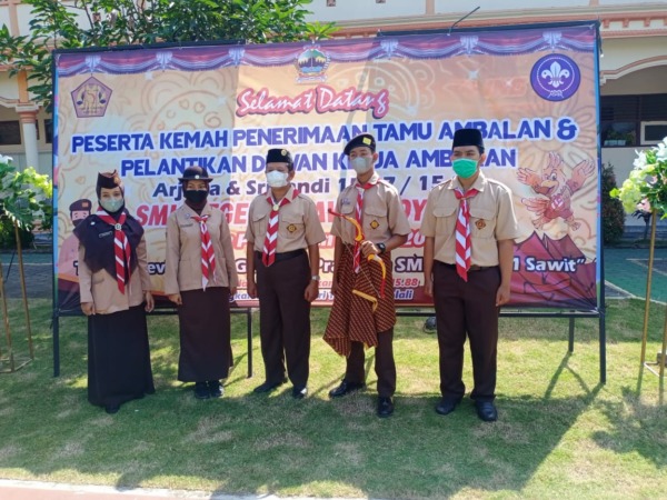 Koordinator Pembina Pramuka, Ratna Sawitri (paling kiri) dan Kepala SMKN 1 Boyolali sekaligus Kamabigus Pramuka, Badari (tengah) menyambut kedatangan peserta kemah di sekolah setempat. (RAGIL LISTIYO/RADAR SOLO)