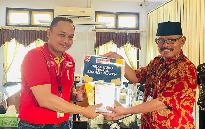 SIMBOLIS: People Development Manager Alfamart Cabang Klaten Beny Kurniawan (kiri) hibahkan buku kepada Kepala SMKN 1 Klaten Narimo. ANGGA PURENDA/RADAR SOLO