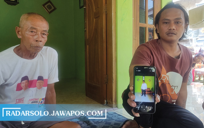 CARI TITIK TERANG: Niko, tunjukkan foto Alan semasa masih hidup kepada wartawan di rumahnya, Selasa (19/7). (IWAN ADI LUHUNG/RADAR SOLO)