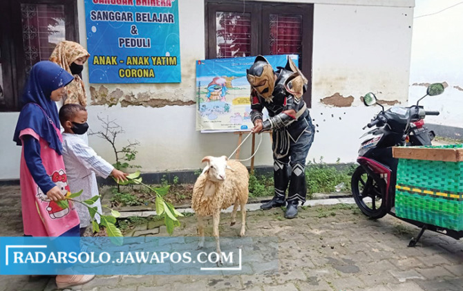 PEDULI: Aksi pegiat sosial mengantar hewan kurban dengan memakai kostum Gatutkaca milenial di salah satu panti asuhan. (IWAN KAWUL/RADAR SOLO)