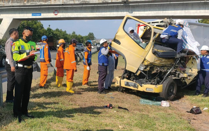 Petugas melakukan evakuasi truk yang terlibat kecelakaan di jalan tol Sragen-Solo, tepatnya di KM 512, Kecamatan Kebakkramat, Karanganyar, Rabu (27/7). (RUDI H/RADAR SOLO)