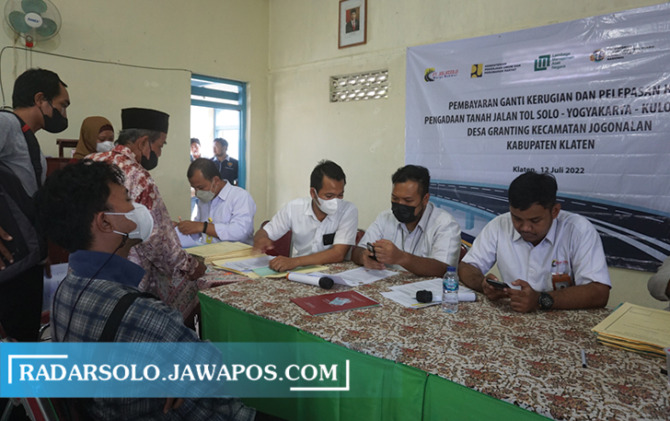 JADI JUTAWAN: Warga menerima pembayaran uang ganti rugi (UGR) proyek Tol Solo-Jogja di aula Desa Granting, Jogonalan, Selasa (12/7). (ANGGA PURENDA/RADAR SOLO)