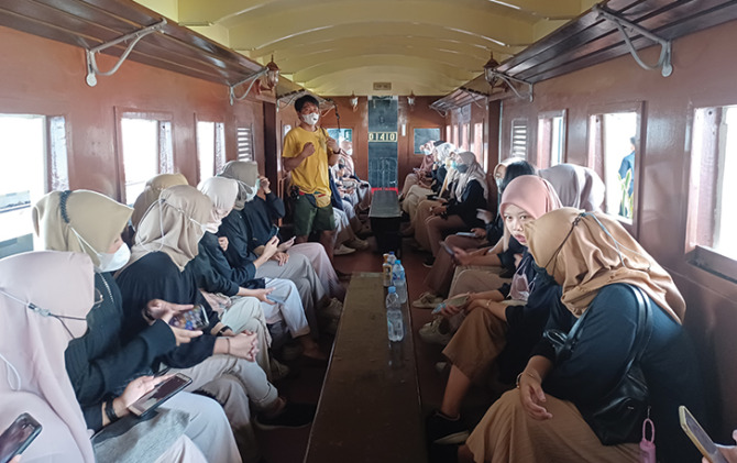 PECINTA SEJARAH: Anggota Komuni Surakarta Walking Tour memandu di gerbong Sepur Kluthuk Jaladara. (DOK. PRIBADI)