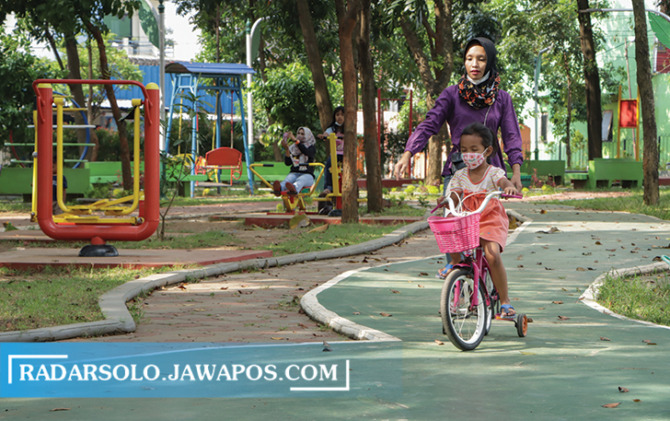 RUANG PUBLIK: Ibu melatih buah hatinya bersepeda di Taman Lansia Jebres. Taman-taman kota dioptimalkan dengan dana CSR. (M. IHSAN/RADAR SOLO
