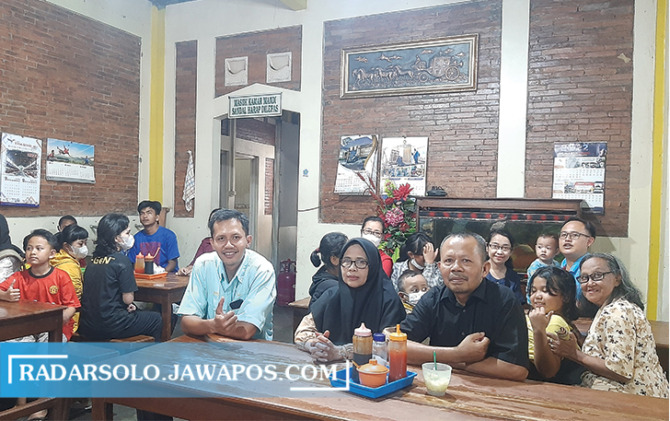 Slamet dan istri (pake kemeja hitam dan kerudung hitam) bersama anak panti asuhan di warung bakso miliknya. (RAGIL LISTIYO/RADAR SOLO)