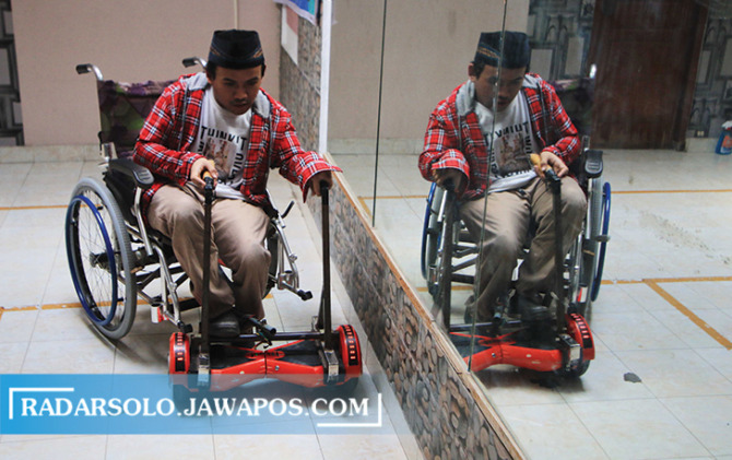KREATIF: Eko Budi Prasetyo memperlihatkan kursi roda yang sudah dimodifikasi buatannya. (ARIEF BUDIMAN/RADAR SOLO)