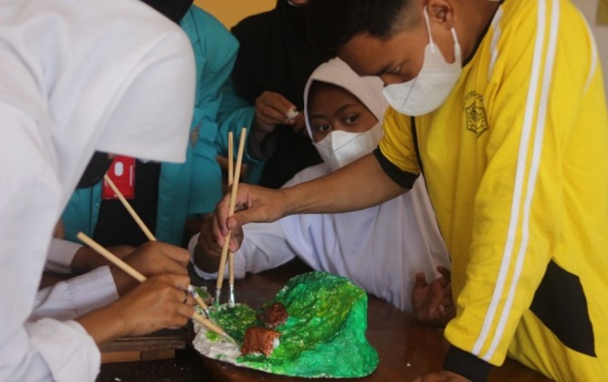 Tim PKM-PM Ular Tangga 3D Berbasis Kearifan Lokal Universitas Muhammadiyah Surakarta (UMS) mengajak guru dan siswa mewarnai miniatur bencana alam di SLB C Putro Oyotasih, Jatinom, Klaten.