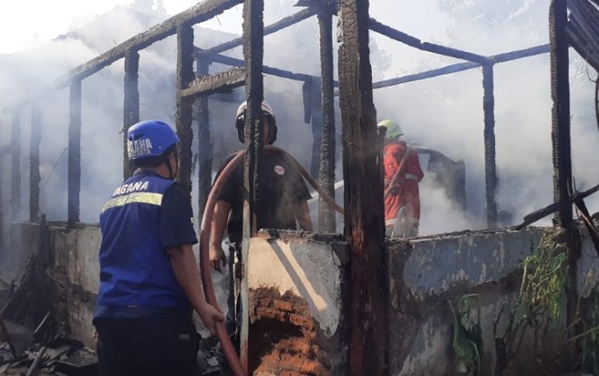 Petugas damkar berupaya memadamkan api yang membakar kos-kosan di Jogobayan RT 02 RW 6, Stabelan, Banjarsari, Solo terbakar hebat, Sabtu (27/8). (ANTONIUS C/RADAR SOLO)