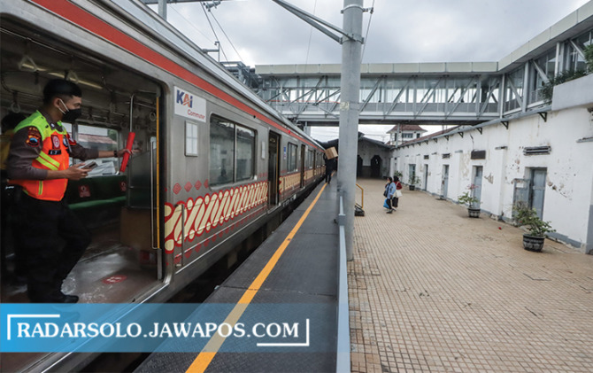 LEBIH CEPAT: Petugas memantau penumpang yang hendak mengakses layanan KRL di Stasiun Solo Balapan belum lama ini. (M. IHSAN/RADAR SOLO)